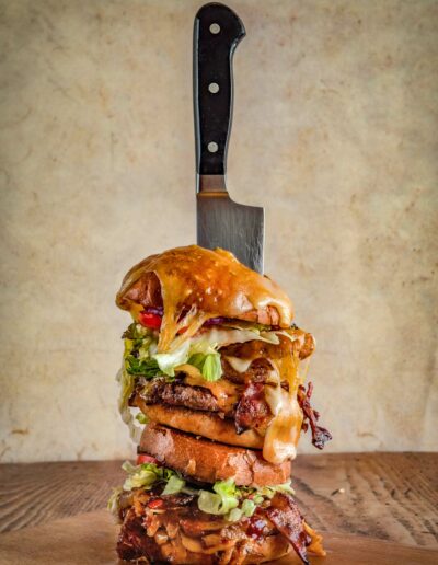 Zwei Burger aufeinander gestapelt mit großem Messer